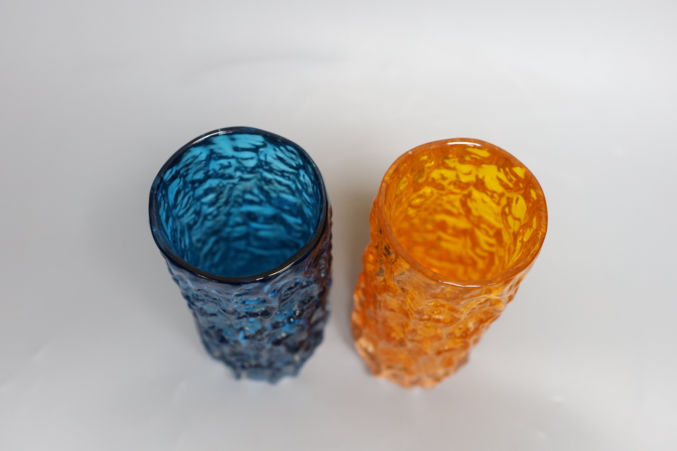 Two Whitefriars 'bark' cylinder vases, model 9689 designed by Geoffrey Baxter in 'tangerine' and 'kingfisher blue' glass, each 19cm high.